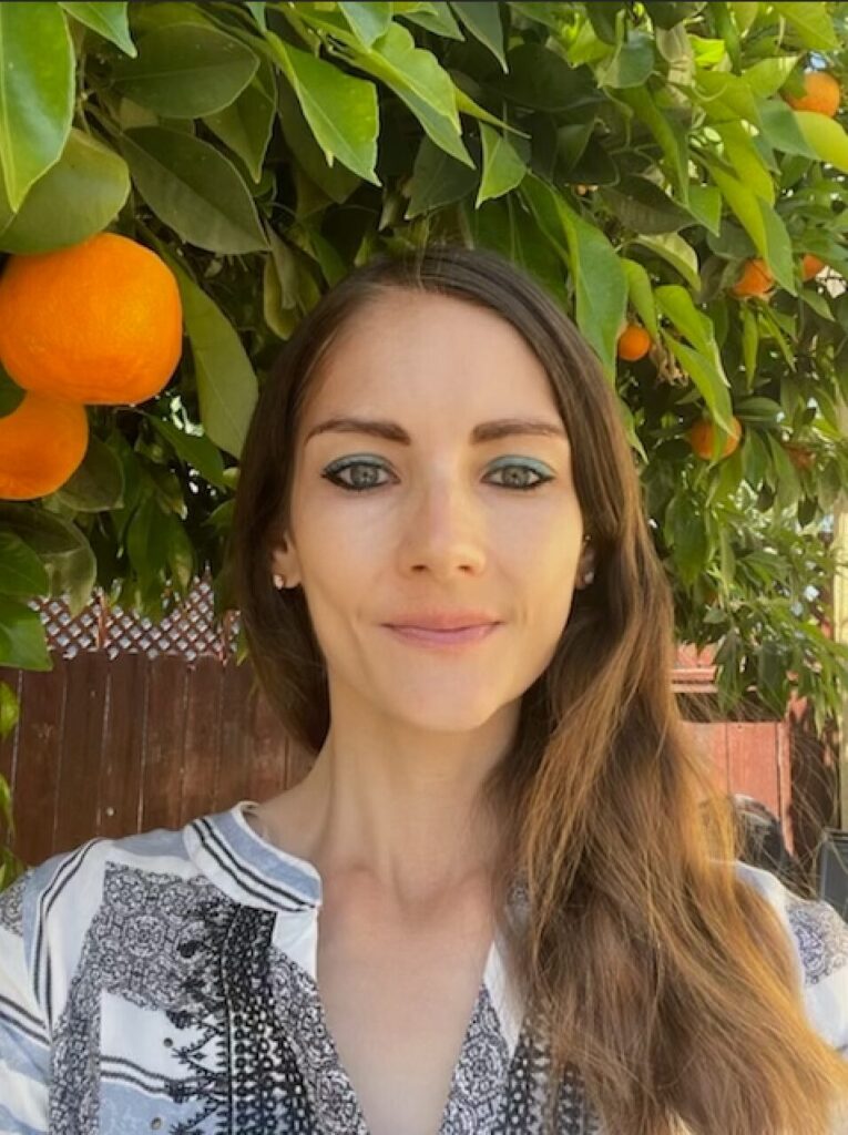 Headshot of Erin Meyer, RD, MS, CPT, GFI near an orange tree