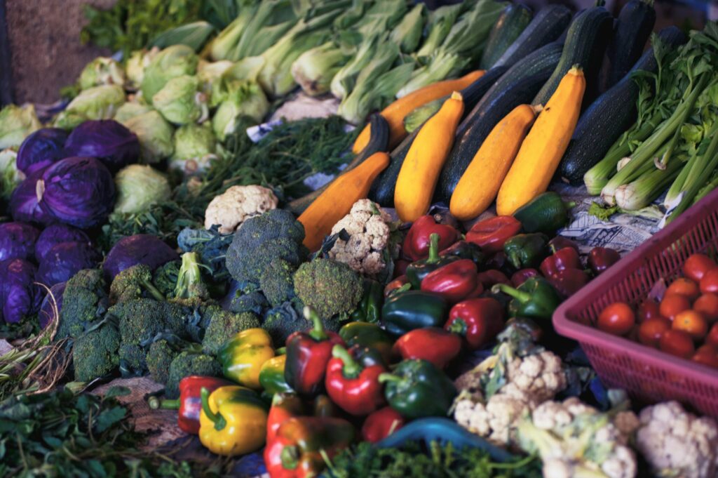 Pile of vegetables like yellow squash, bell peppers and cauliflower 