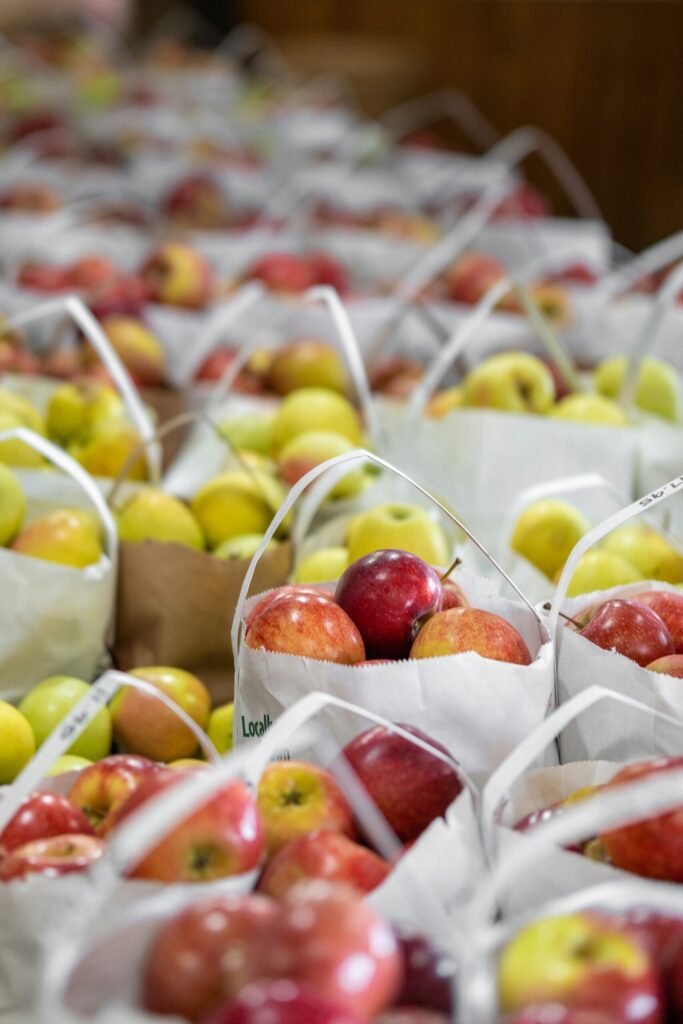 Paper bags filled with red and green apples