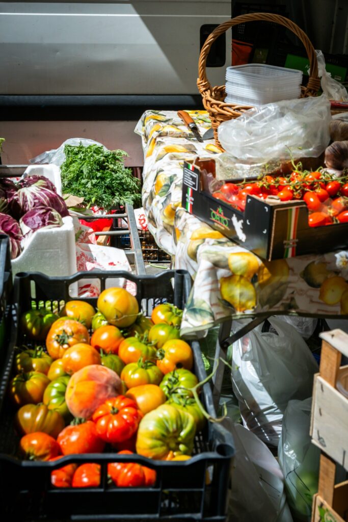 Bins of fruit and vegetables like greens and tomatoes