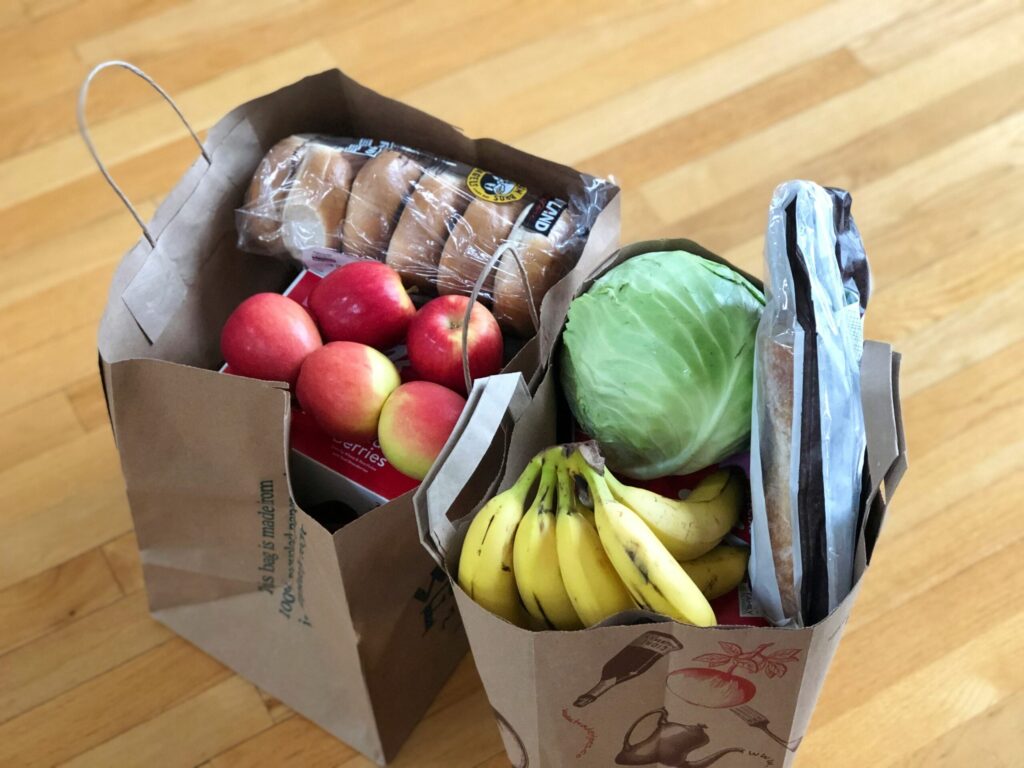 2 bags of groceries with fruit, vegetables and bread/bagels